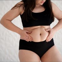 front-view-young-woman-holding-her-belly